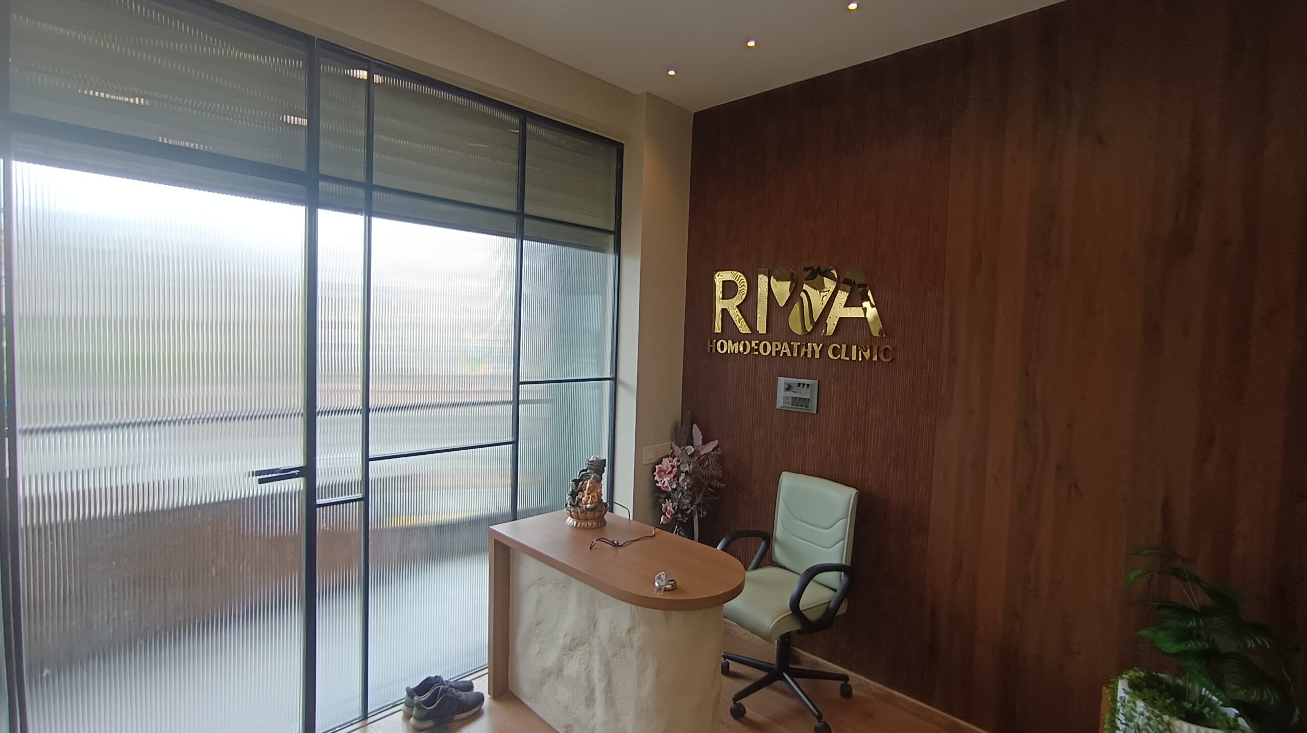 Corporate office corridor with black ceiling grid, recessed lighting, and glass-walled private offices on the side.
