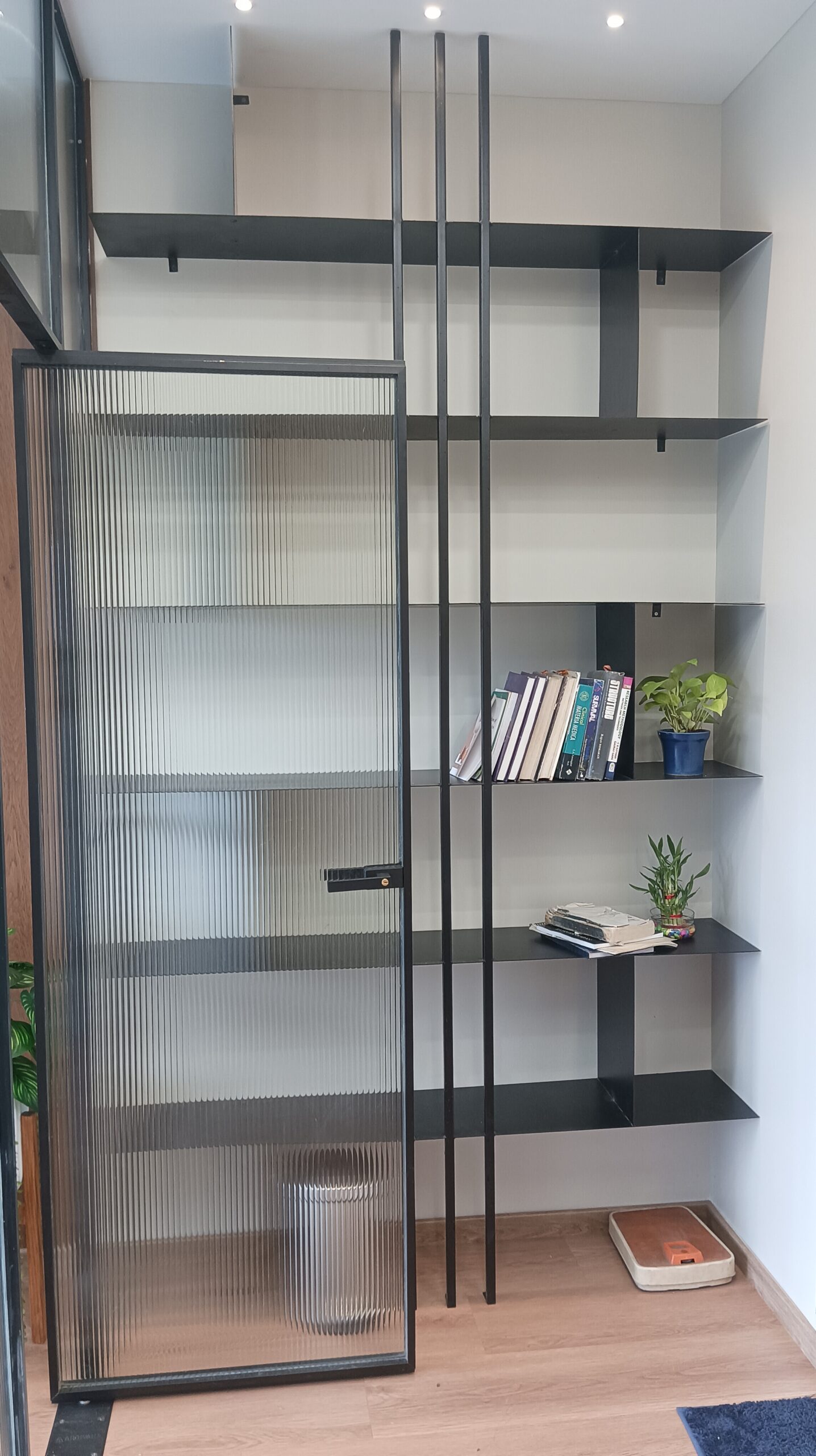 Bright office lounge featuring white curved sofas, round coffee tables, green plants, and large windows allowing ample natural light.