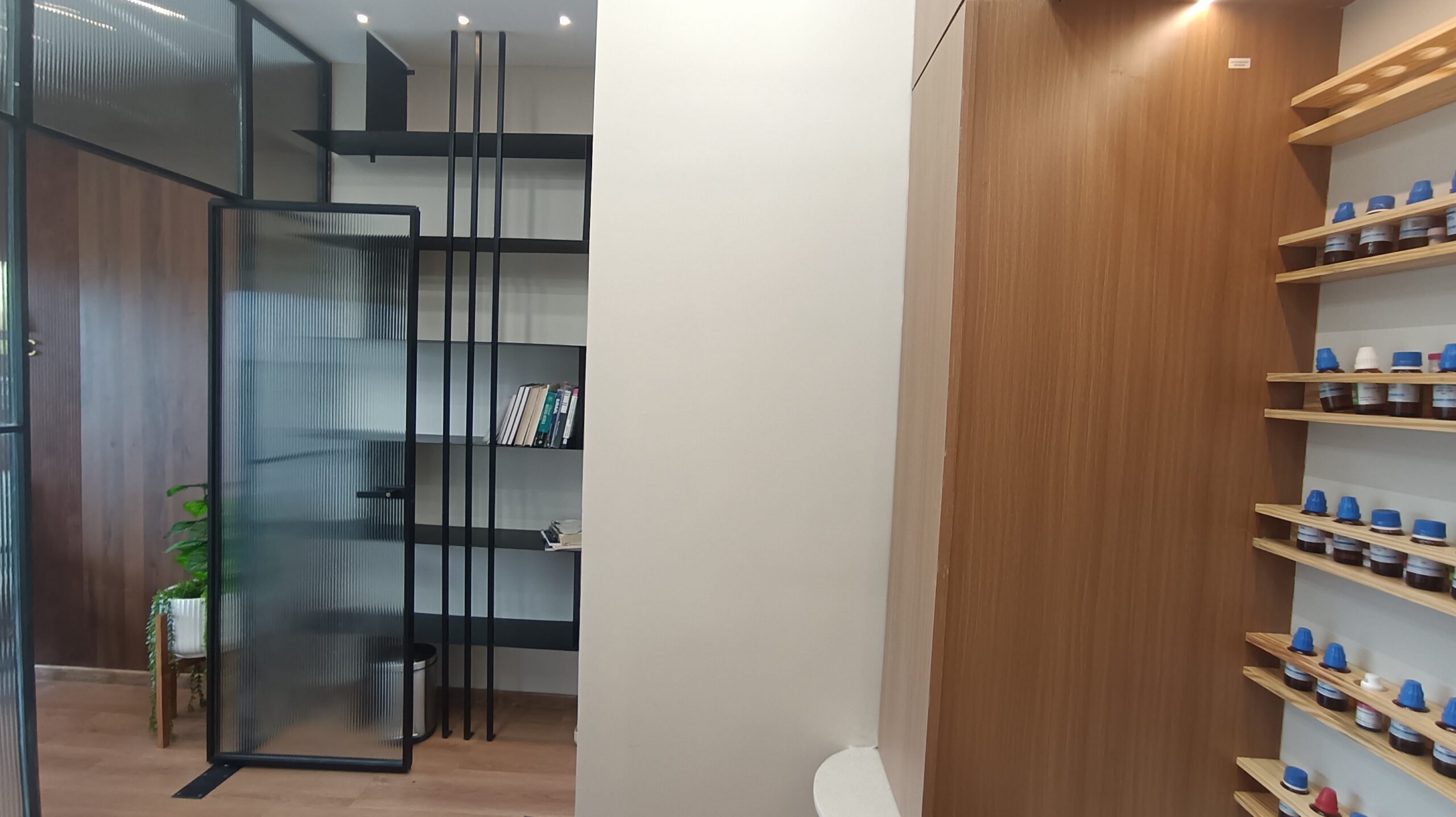 Spacious meeting room featuring a large wooden table surrounded by black chairs, modern pendant lights overhead, and floor-to-ceiling windows