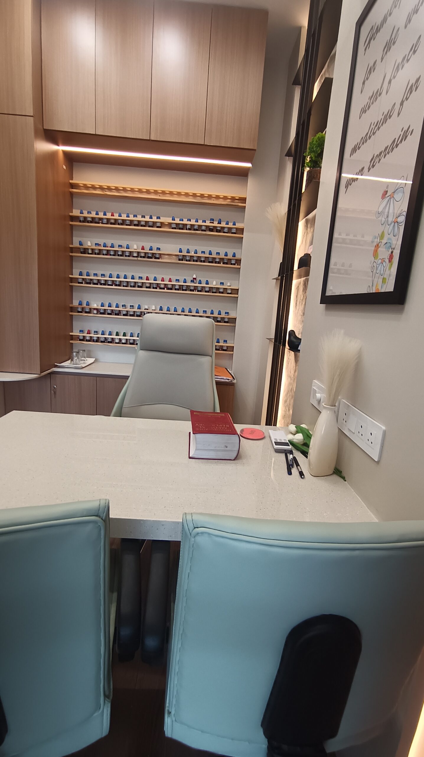 Office pantry featuring built-in stainless steel appliances, wood-finished cabinets, white backsplash tiles, and under-cabinet lighting.