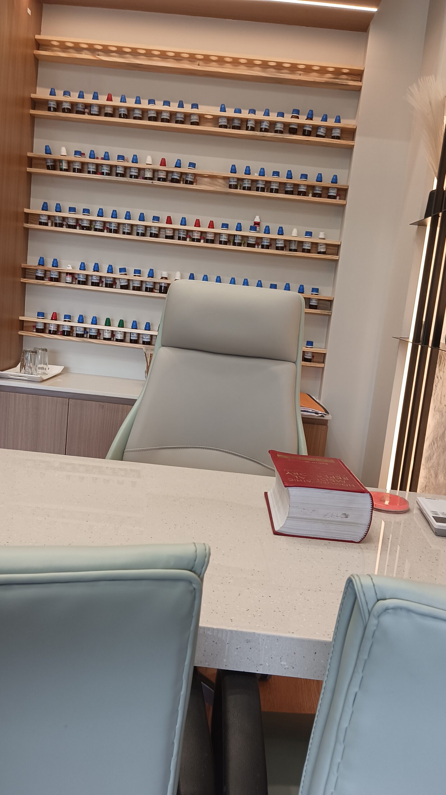 Comfortable lounge area featuring cushioned seating, a small round table, and decorative acoustic wall panels in neutral tones